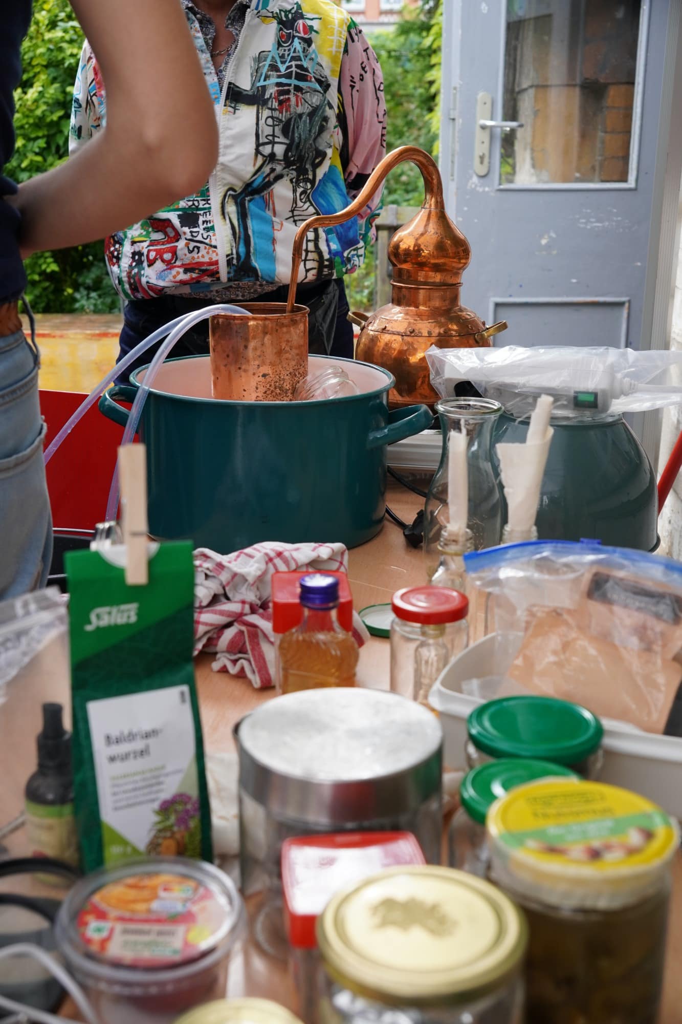 a table with a distiller and objects and someone standing beside