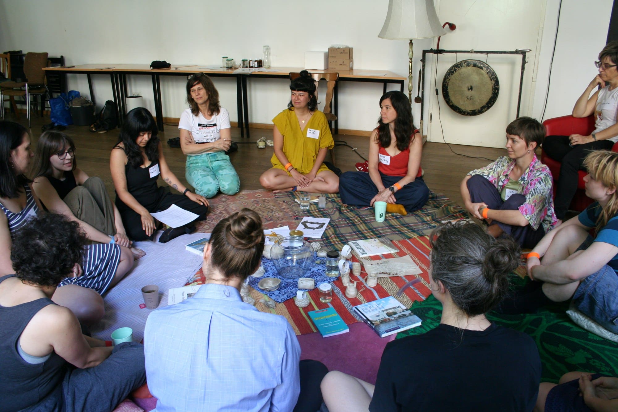 A group of women seated on blankets in a room 