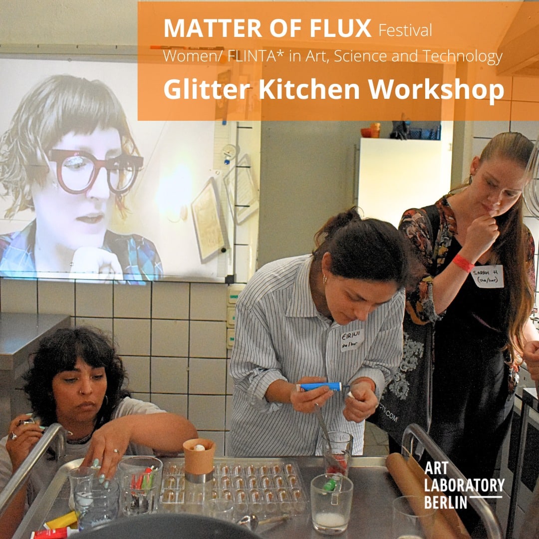 Three women working around a metal table a projection on the wall show the head of another woman. the words: "Matter of Flux Festival Festival  Women/FLINTA* in Art, Science and Technology Glitter Kitchen Workshop"
