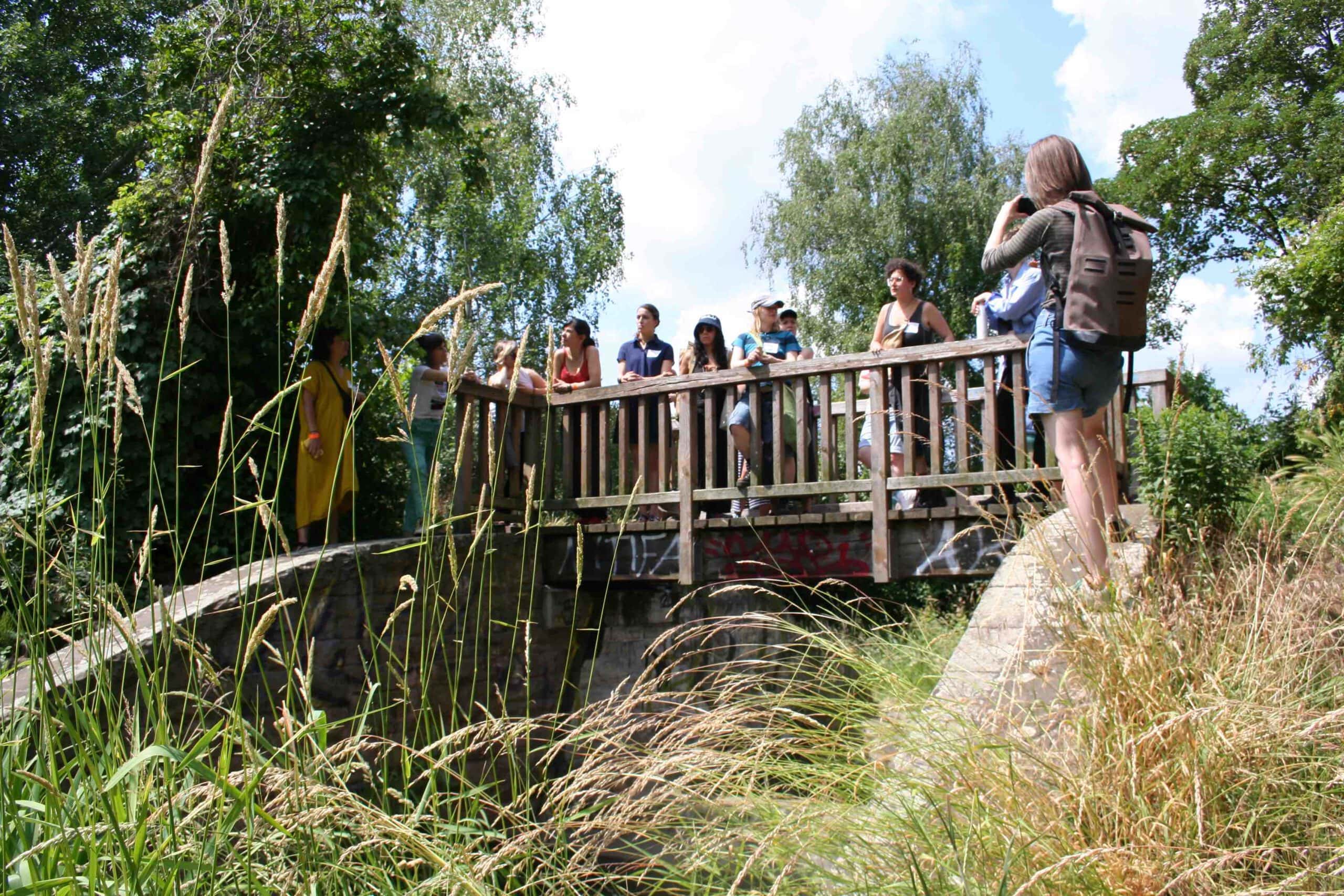 a group of women standing on or near a small foot bridge
