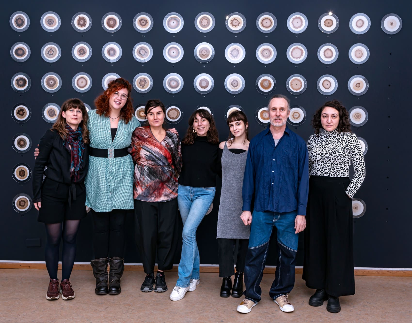 a group of people standing in front of artwork