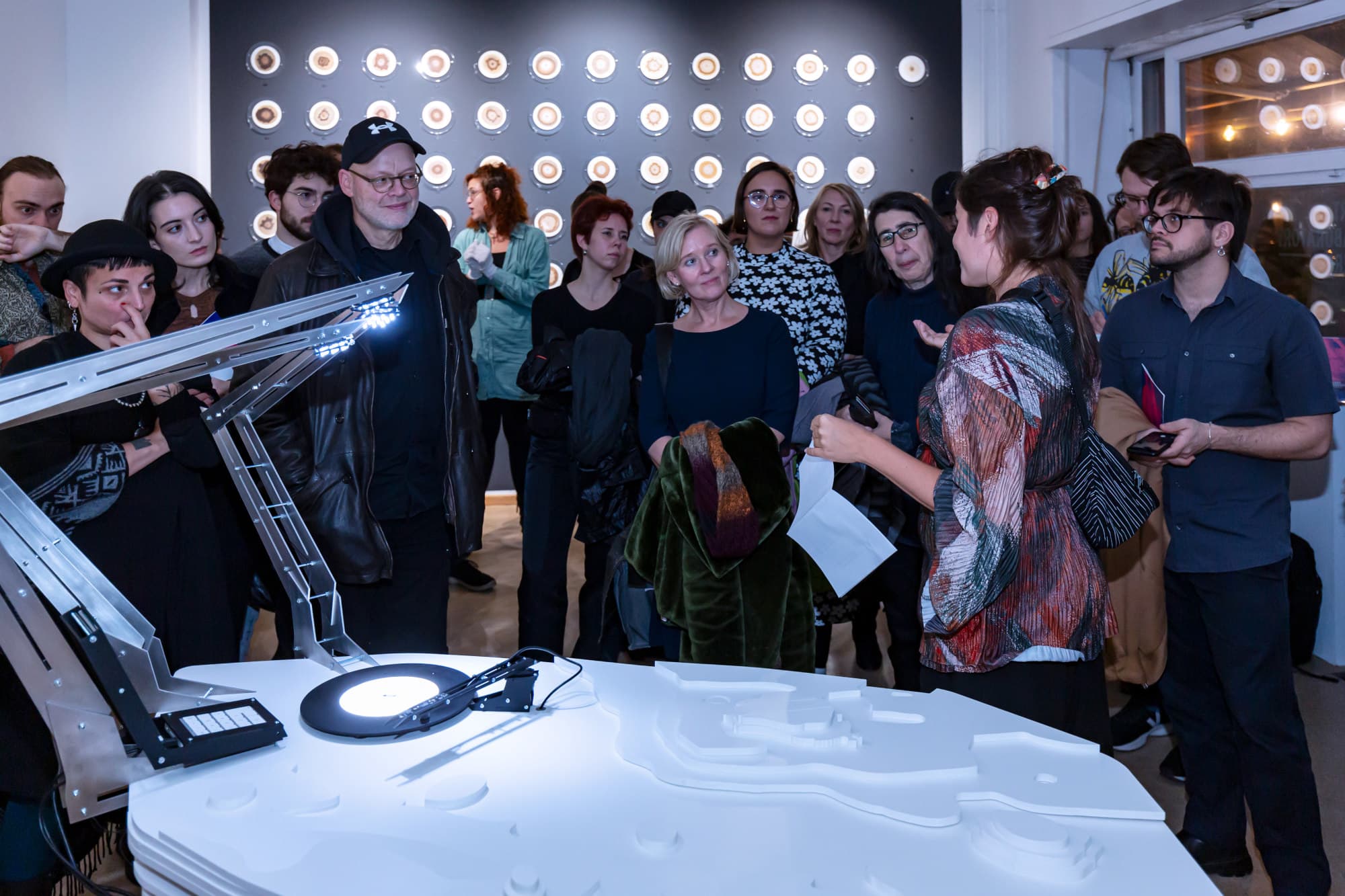 People listening to the artist speak at the opening of the exhibition