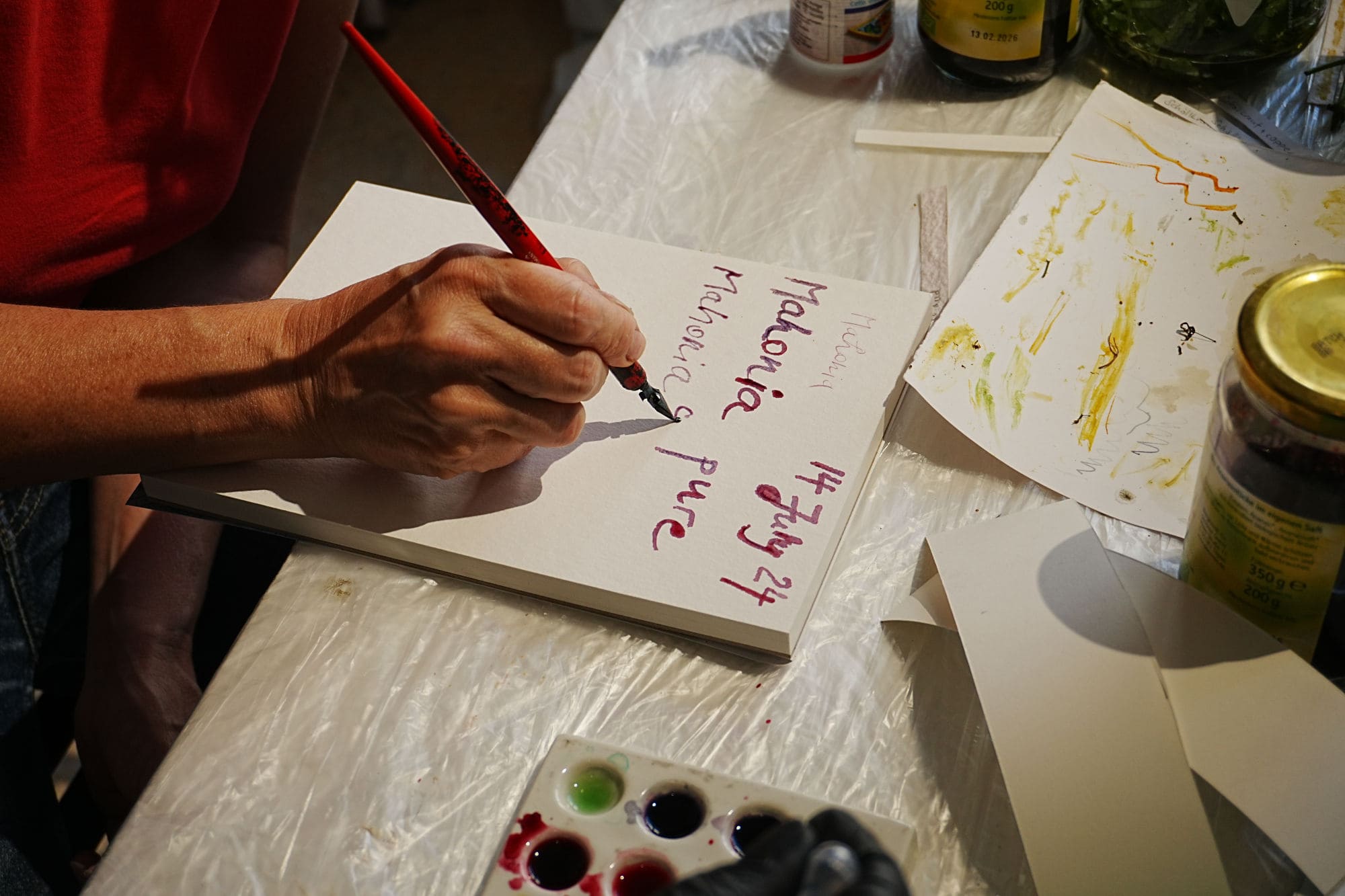 eine Hand, die mit violetter Tinte auf Papier schreibt