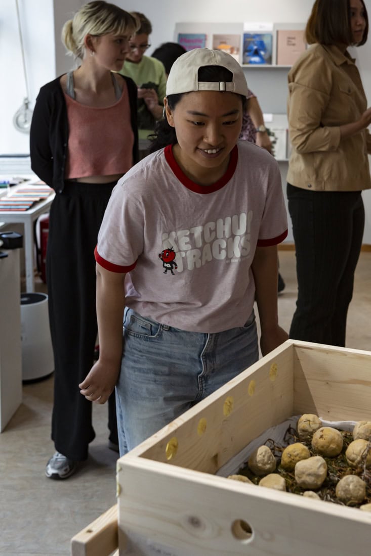 a woman staring at a box filled with balls of nuruk