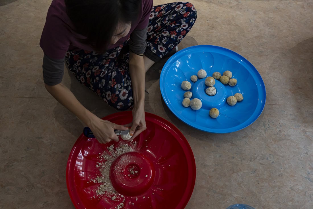 a hand making balls of dough