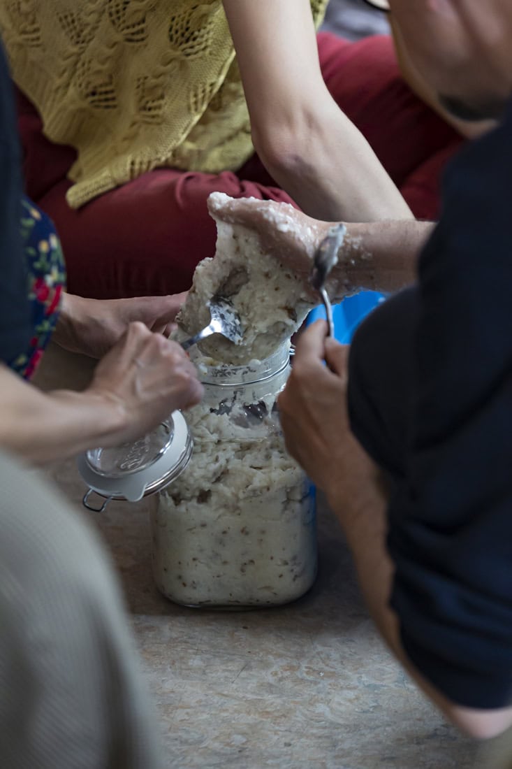 hands placing rice dough in a jar