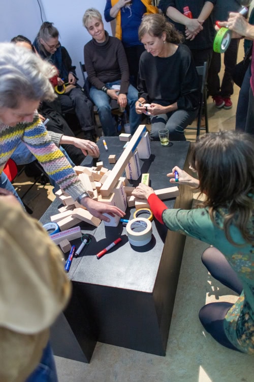 people building with wooden blocks