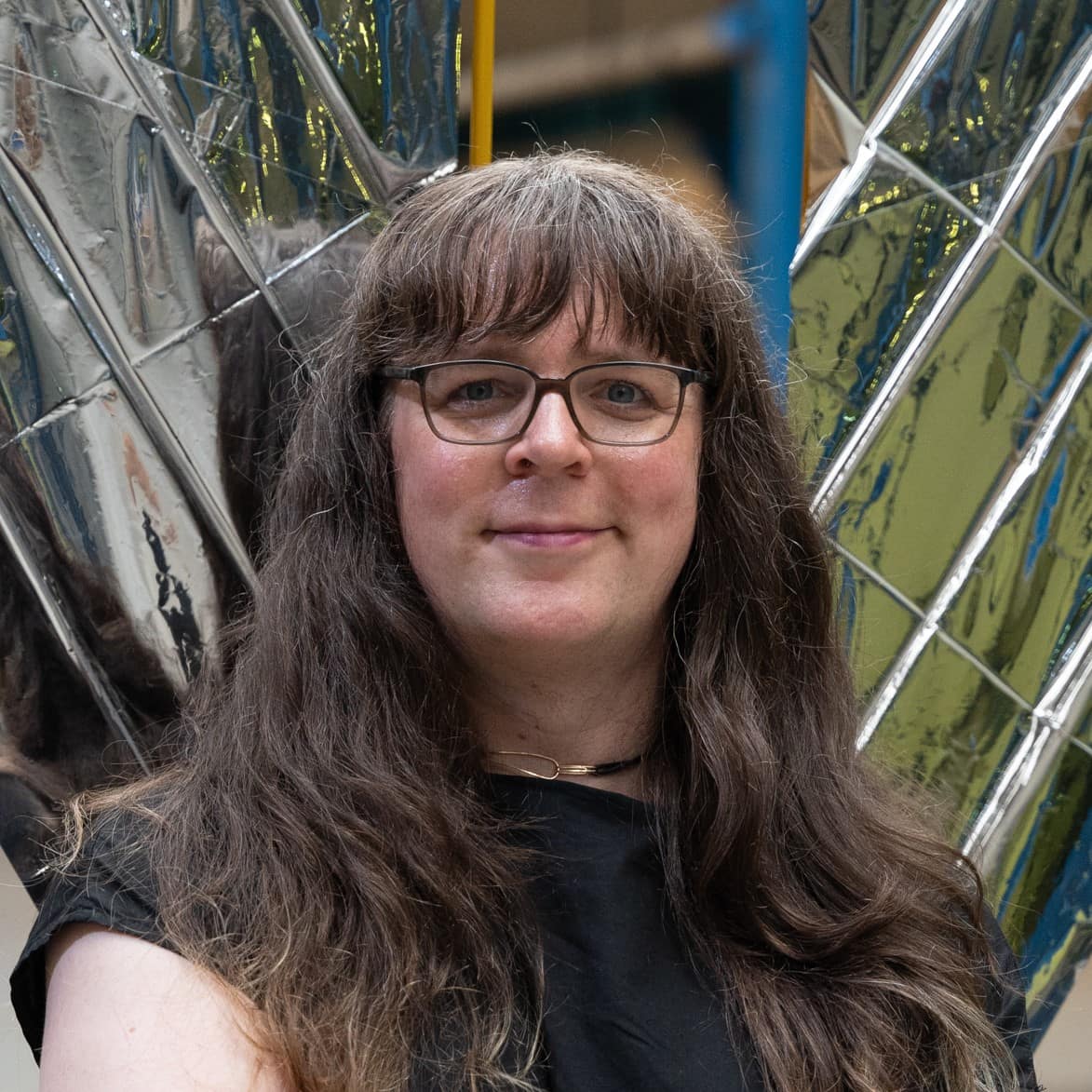 portrait of Adriana Knouf in front of silver model of a solar sail