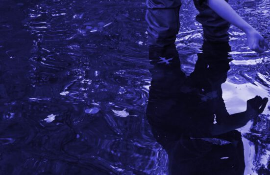 blue- violet photograph of a person standing in water