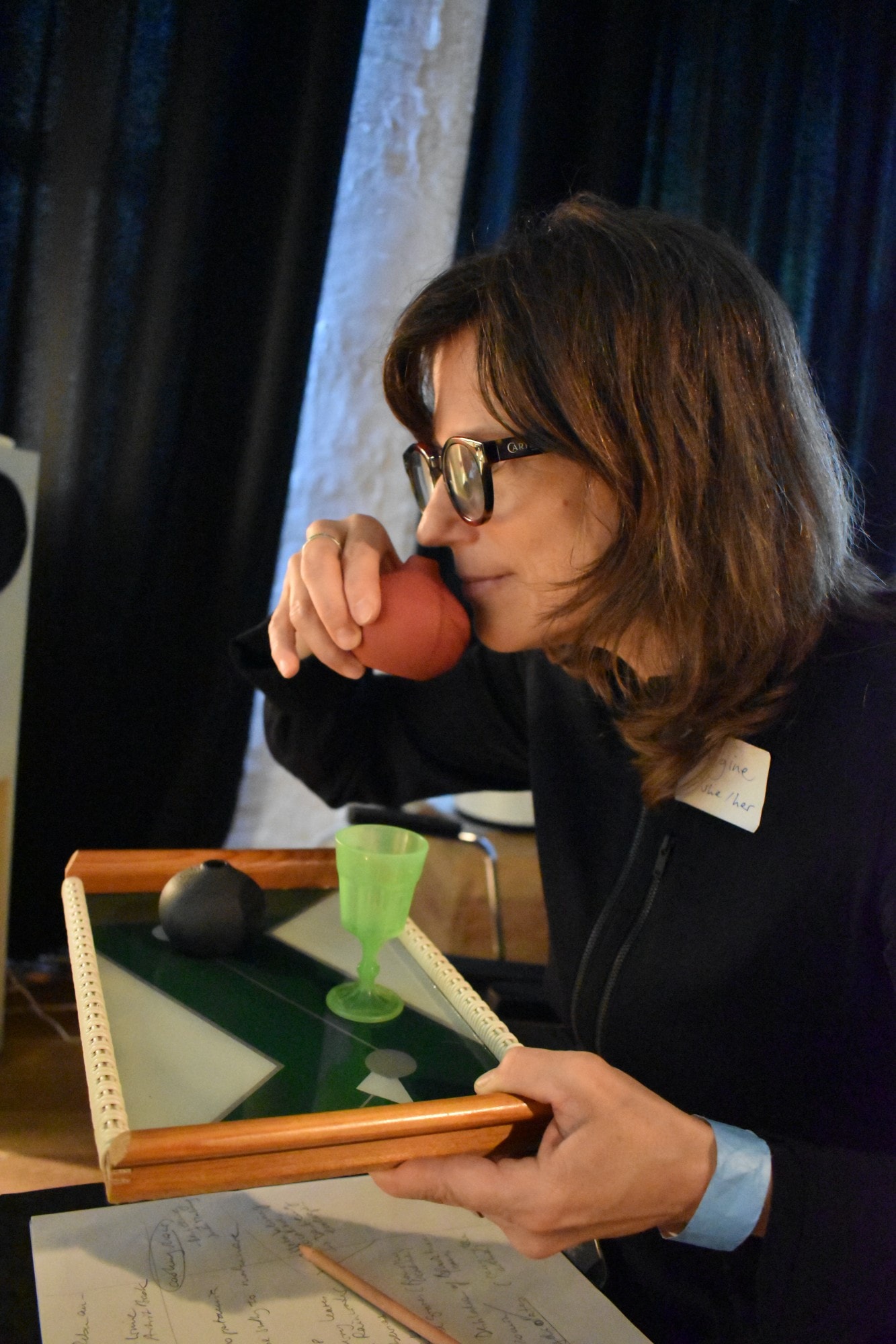 a woman smells an apple and holds a tray