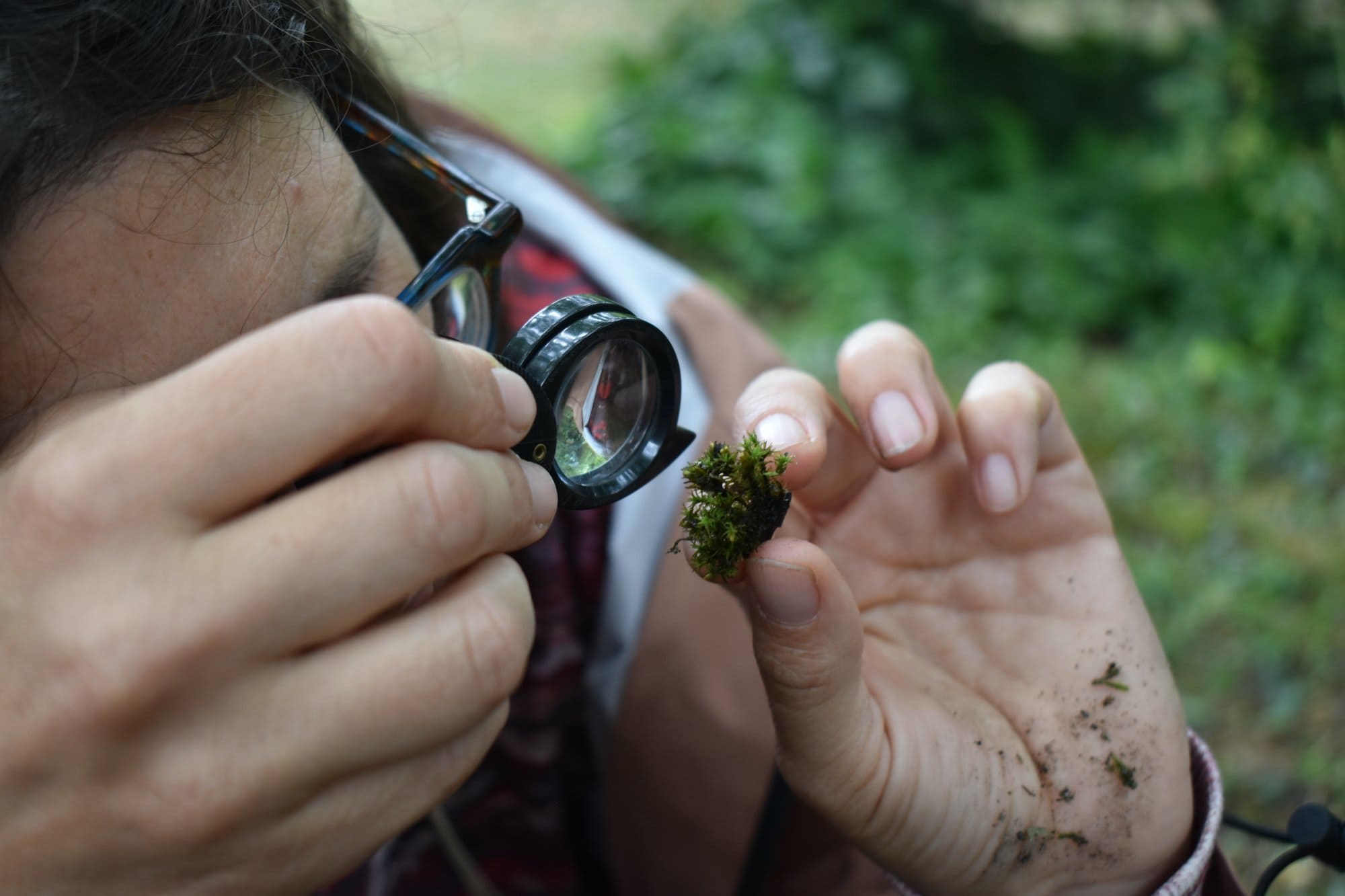 a person holding a loop in one hand and moss in the other