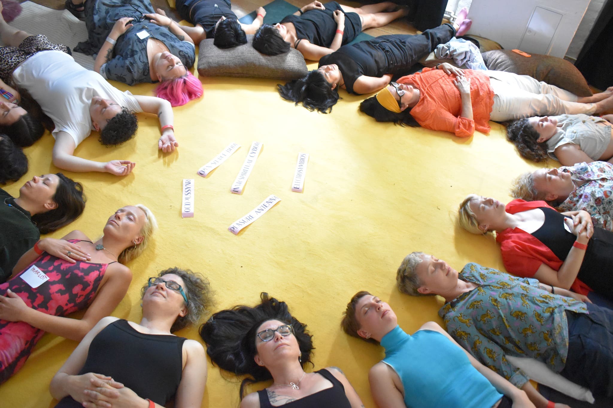 a group of woman laying on the floor in a circle 