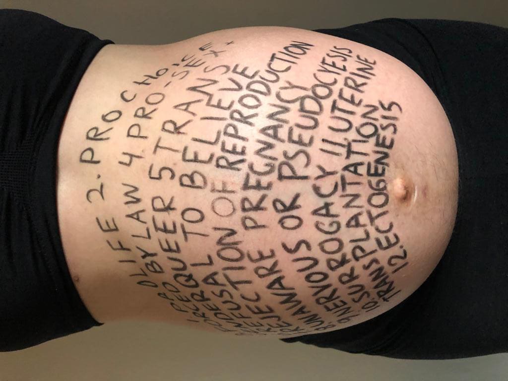 a pregnant belly with text written on it