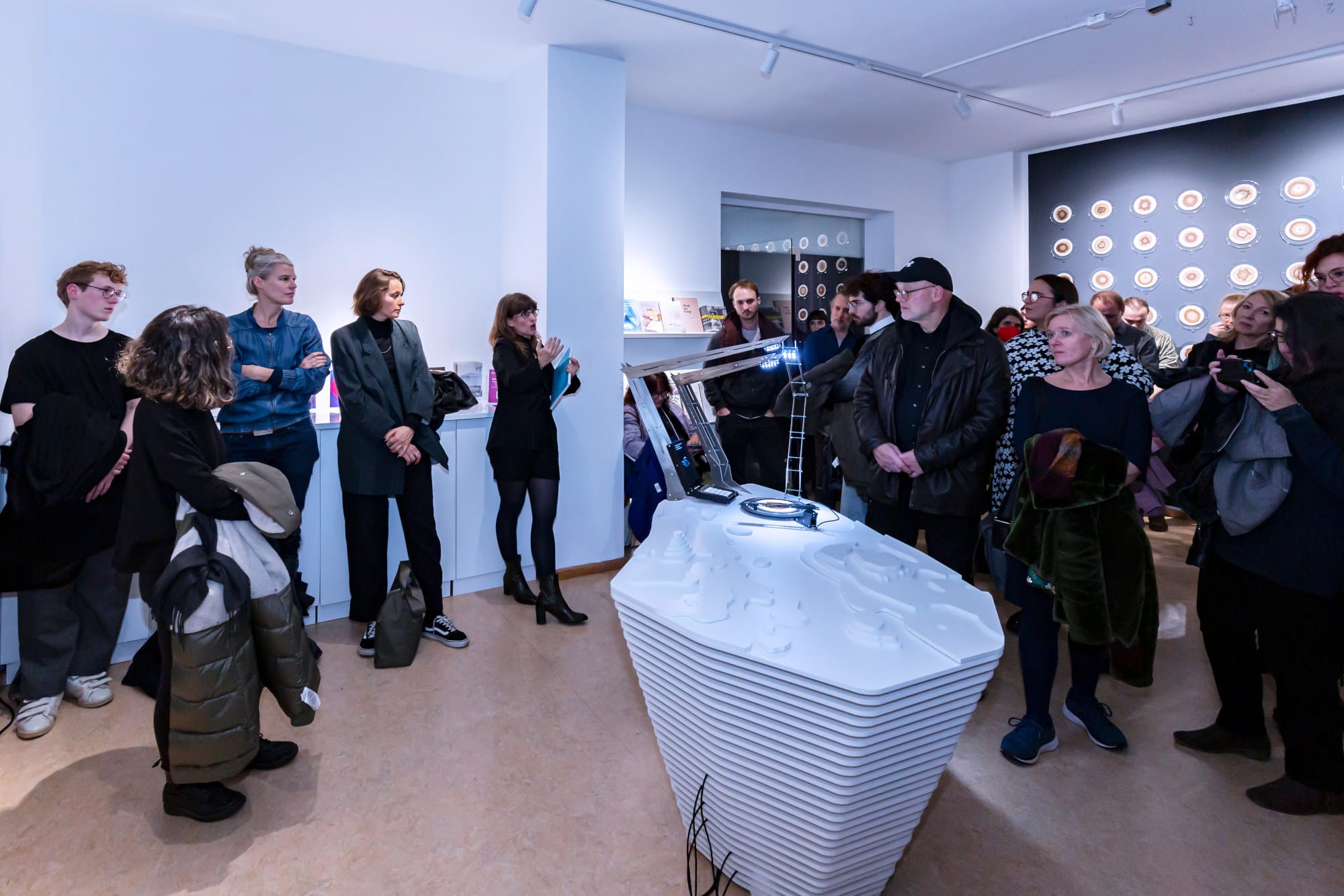People listening to a curator speak at the opening of the exhibition