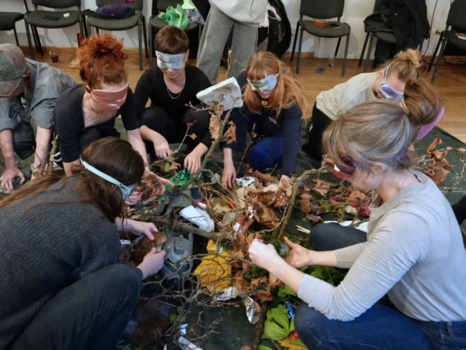 Menschen in einer Workshop, die auf Händen und Knien bauen