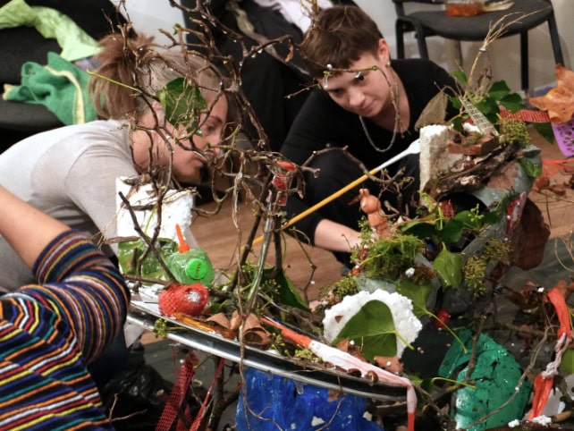 Menschen in einer Workshop, die auf Händen und Knien bauen
